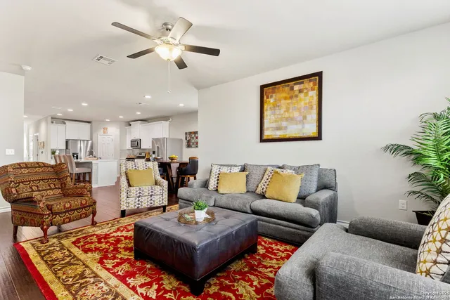 a living room with furniture kitchen view and a potted plant