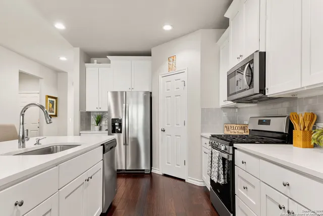 a kitchen with stainless steel appliances granite countertop a refrigerator stove and sink