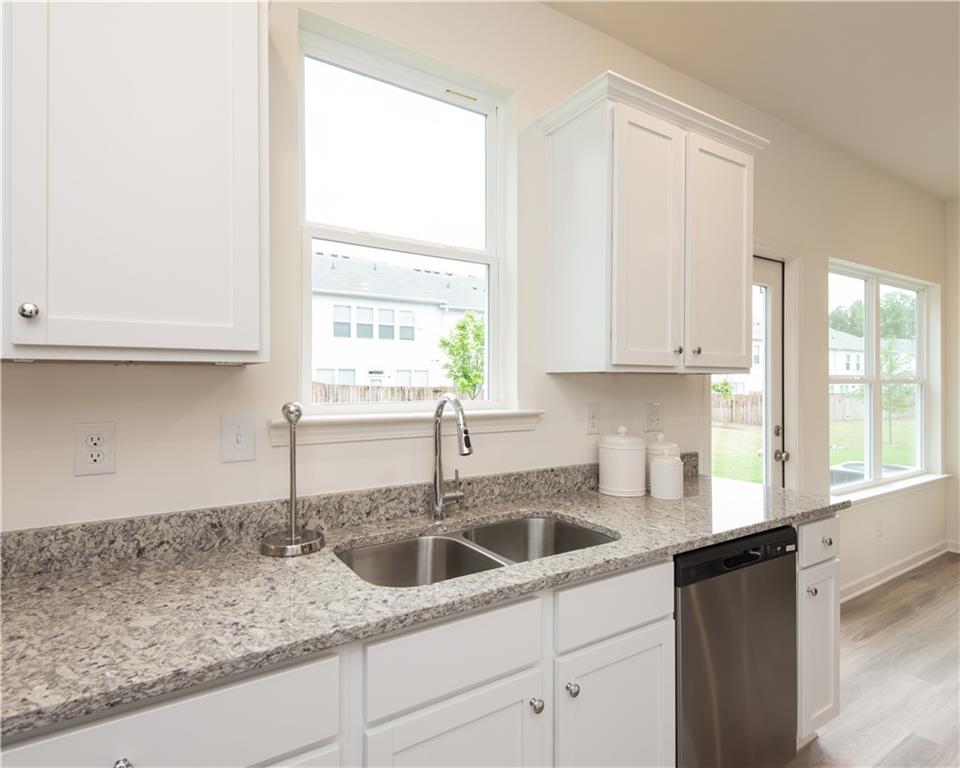 1819 Dawn Road, Unit 16 Conyers, GA 30013 - Photo 12 of 28 a kitchen with granite countertop white cabinets and a window