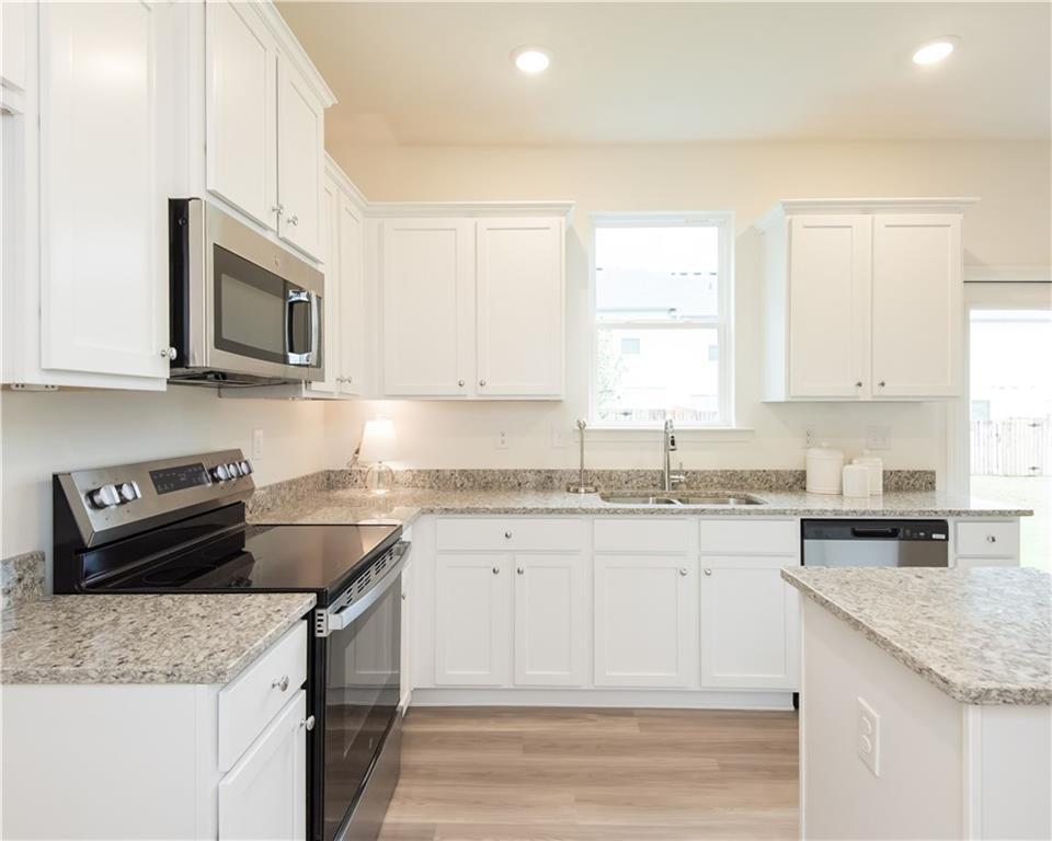 1819 Dawn Road, Unit 16 Conyers, GA 30013 - Photo 15 of 28 a kitchen with granite countertop a sink stove and microwave