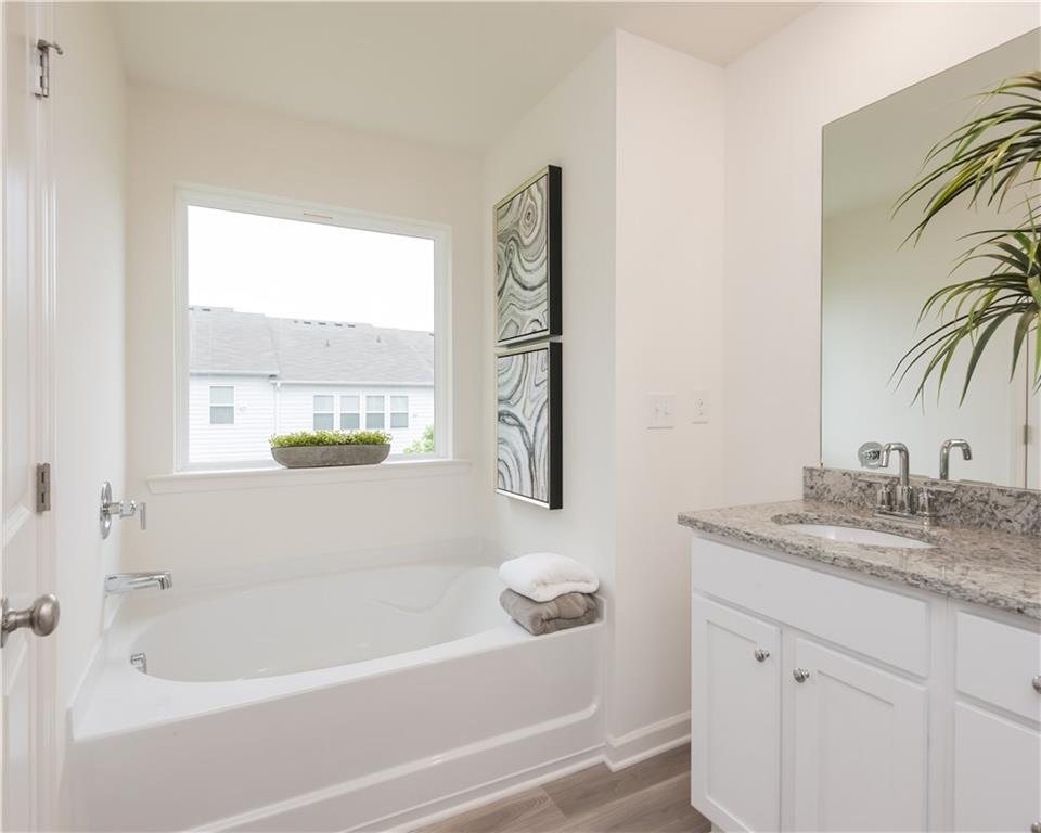 1819 Dawn Road, Unit 16 Conyers, GA 30013 - Photo 26 of 28 a bathroom with a granite countertop sink a toilet and a bathtub