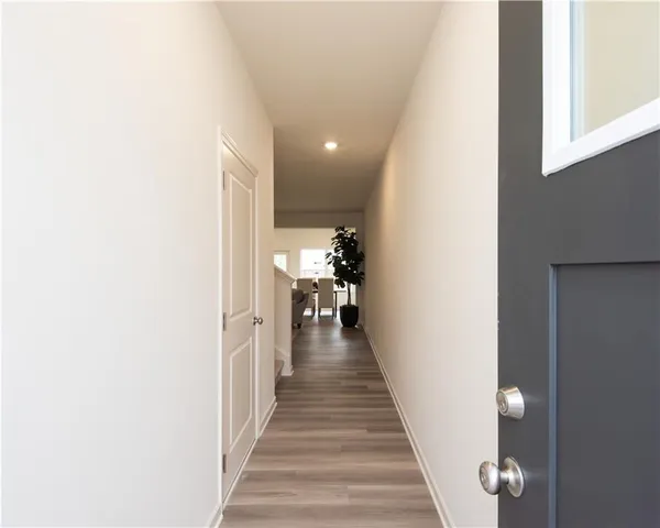 a view of a hallway with wooden floor and staircase