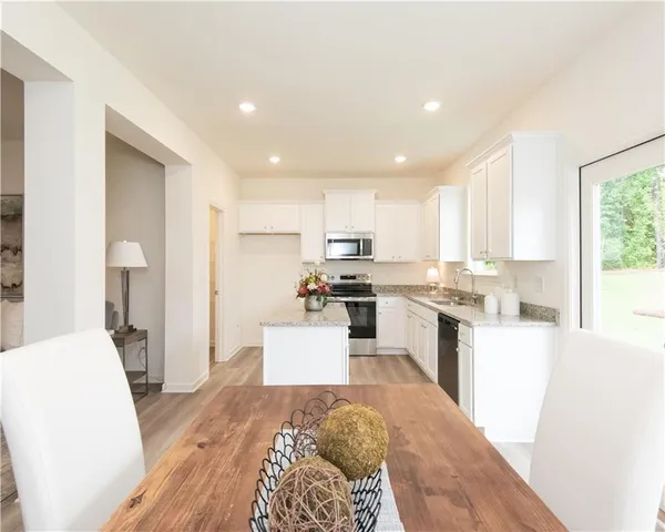 a large white kitchen with sink stove and refrigerator
