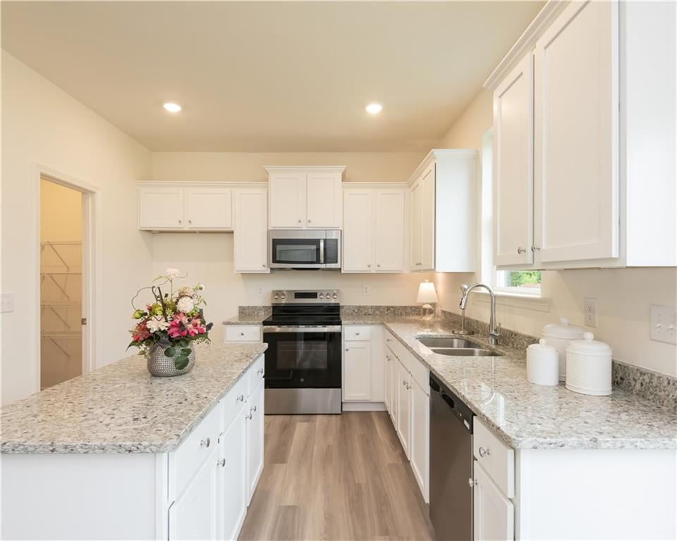 1819 Dawn Road, Unit 16 Conyers, GA 30013 - Photo 10 of 28 a kitchen with stainless steel appliances granite countertop a sink stove and cabinets