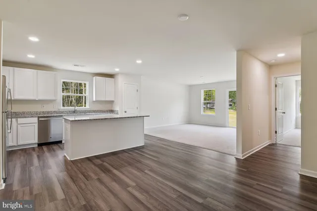 a large kitchen with a wooden floor and a large window