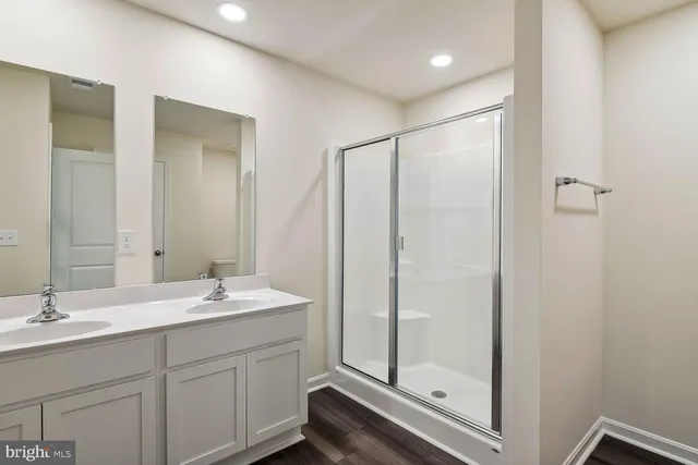 a bathroom with a double vanity sink mirror and shower