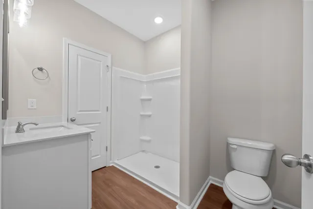 a bathroom with a granite countertop sink a toilet and shower