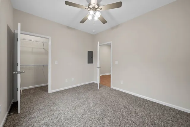 a view of an empty room and chandelier fan