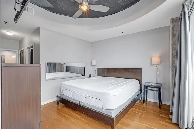 a bedroom with a bed and wooden floor