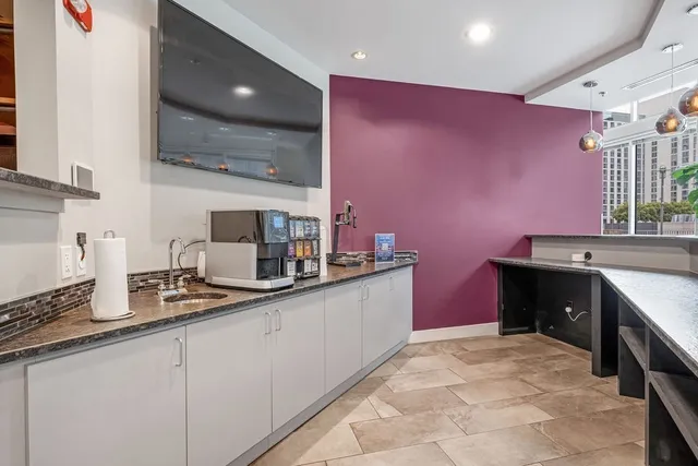 a view of kitchen with stainless steel appliances kitchen island granite countertop living room