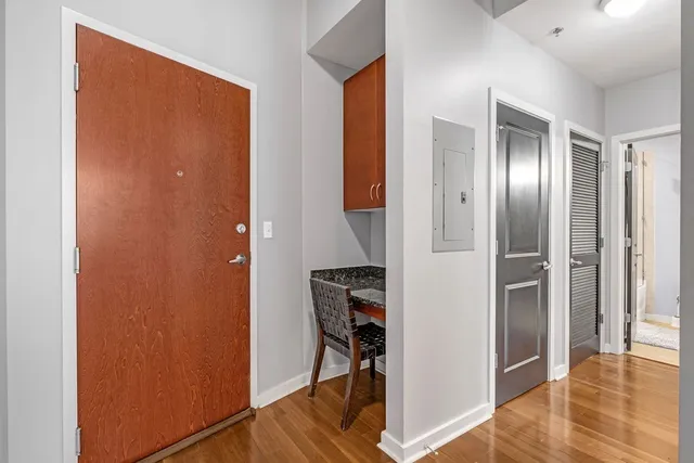 a view of a hallway with wooden floor and closet