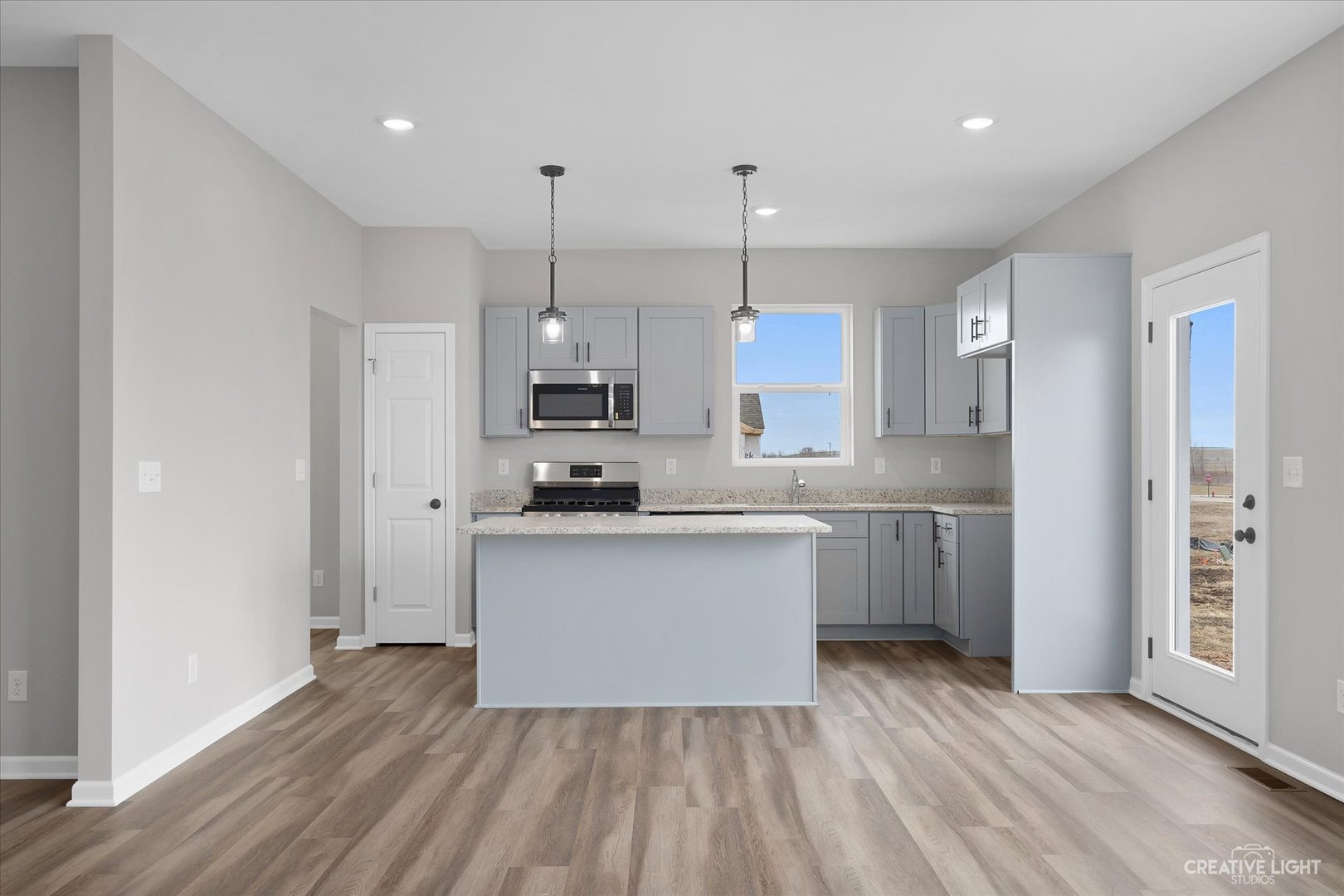 501 Hahn Drive Cortland, IL 60112 - Photo 7 of 27 a kitchen with stainless steel appliances granite countertop a refrigerator a sink dishwasher a stove and white cabinets with wooden floor