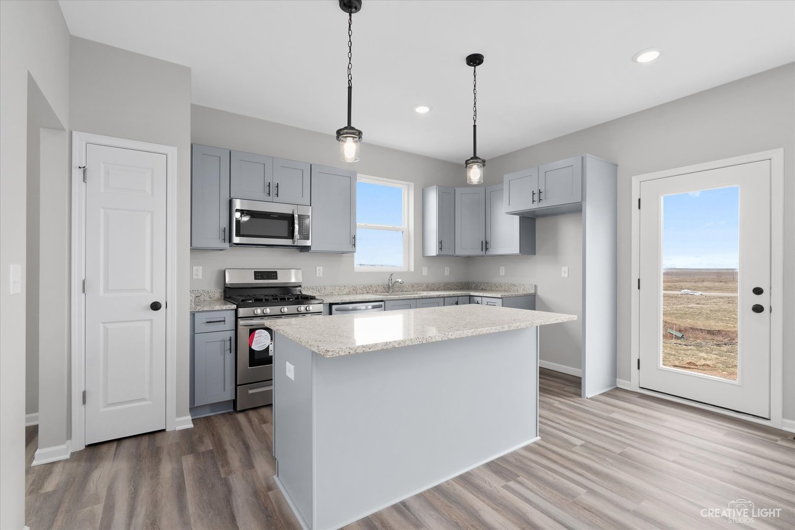 501 Hahn Drive Cortland, IL 60112 - Photo 9 of 27 a kitchen with stainless steel appliances granite countertop a sink a stove a refrigerator and white cabinets with wooden floor