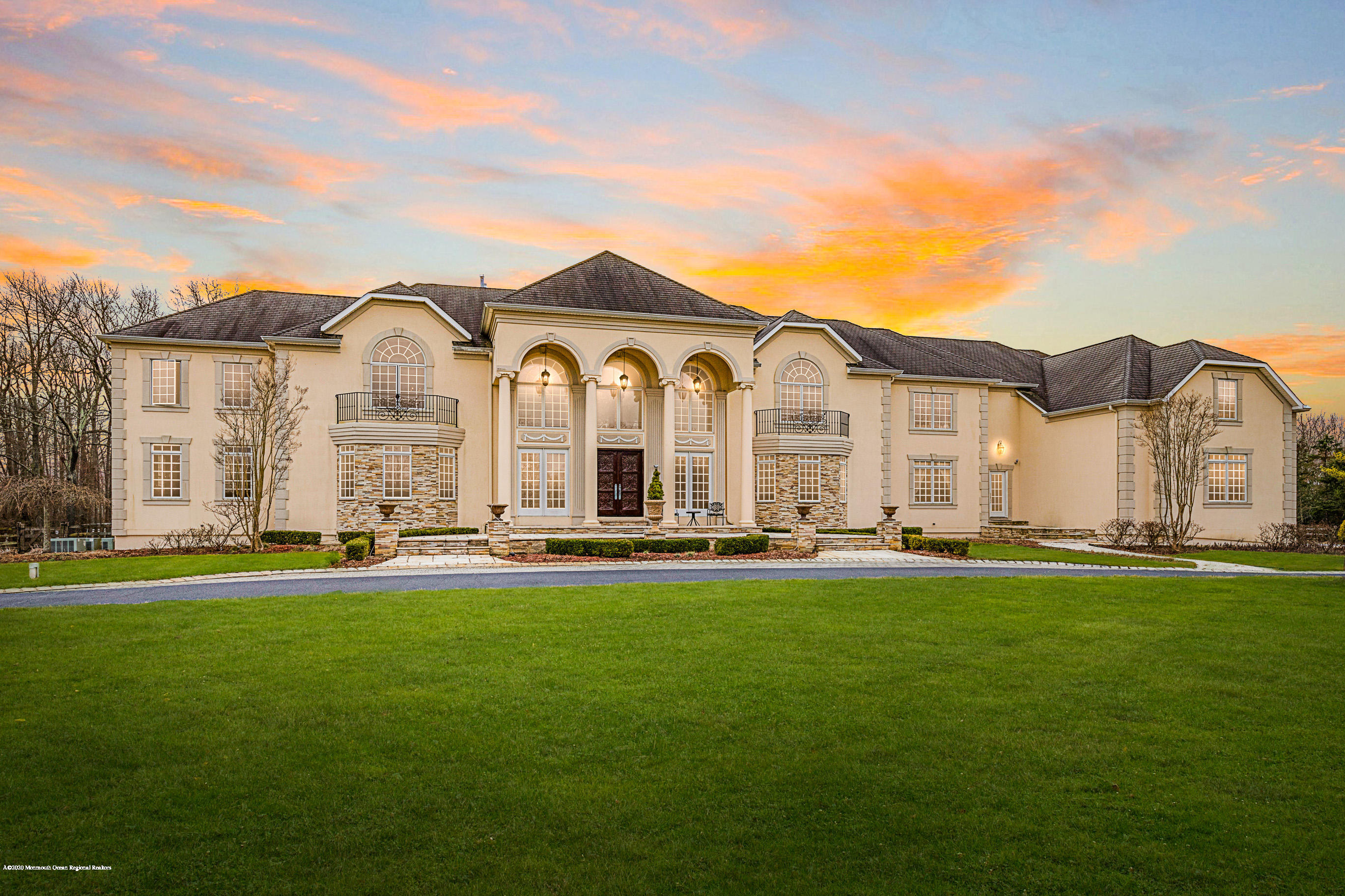 a view of a big house with a big yard and large trees