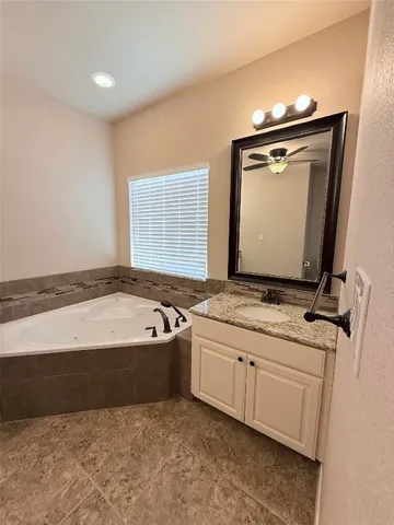 a bathroom with a tub sink and mirror