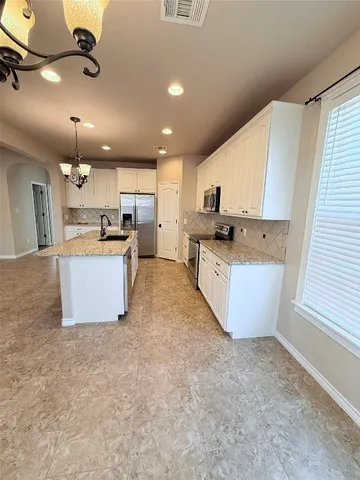 a large kitchen with a large counter top appliances and cabinets
