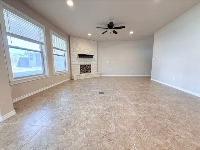 an empty room with windows and ceiling fan