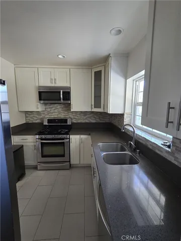 a kitchen with a sink stove and microwave