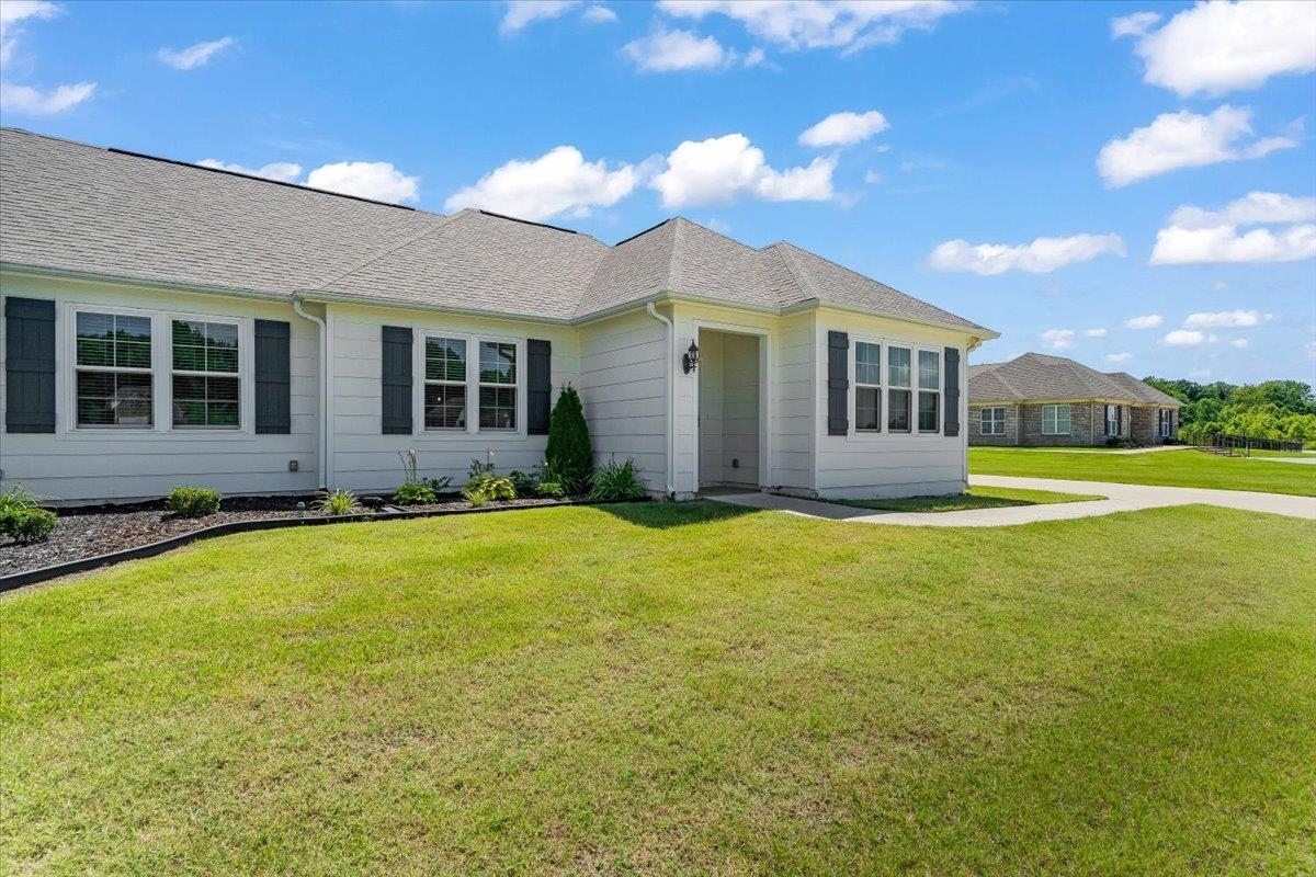 415 Abbey Road, Unit D Munford, TN 38058 - Photo 27 of 35 Single-story home featuring a light-colored exterior siding, dark louvered shutters, and a gray shingle roof