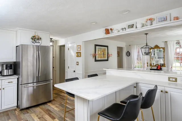 a kitchen with stainless steel appliances a refrigerator a sink a stove and white cabinets