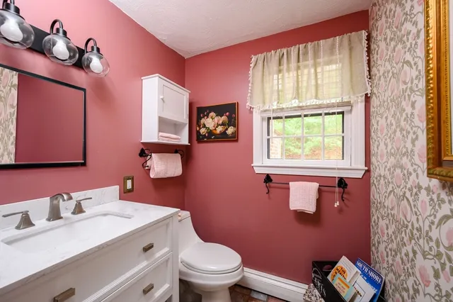 a bathroom with a granite countertop toilet sink and mirror