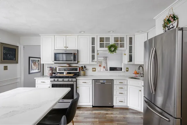 a kitchen with stainless steel appliances a refrigerator stove microwave and sink