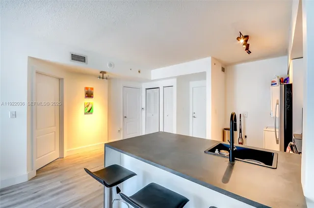 a view of a kitchen with a sink and a refrigerator