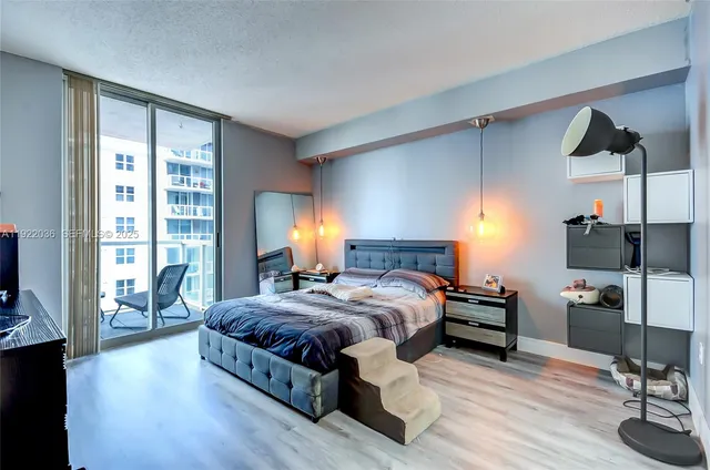 a bedroom with a bed wooden floor and window