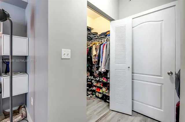 a view of walk in closet with clothes and shoes