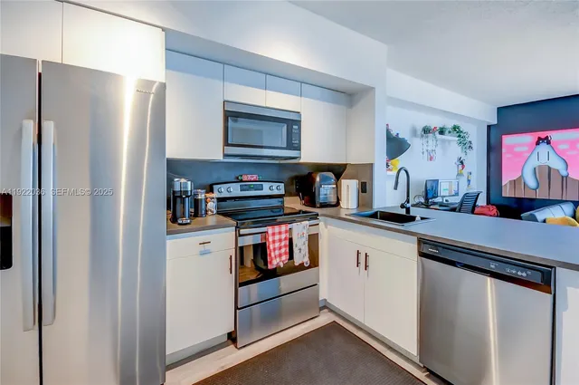 a kitchen with stainless steel appliances a refrigerator sink and stove top oven