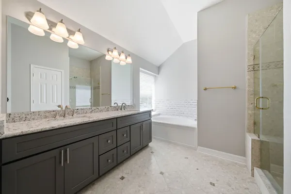 a bathroom with a granite countertop sink a large mirror and a shower