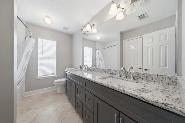 a bathroom with a granite countertop sink a large mirror and a bathtub