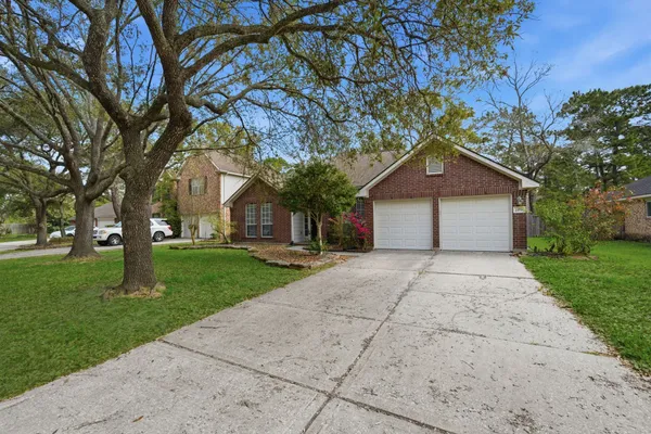 a front view of a house with a yard and trees
