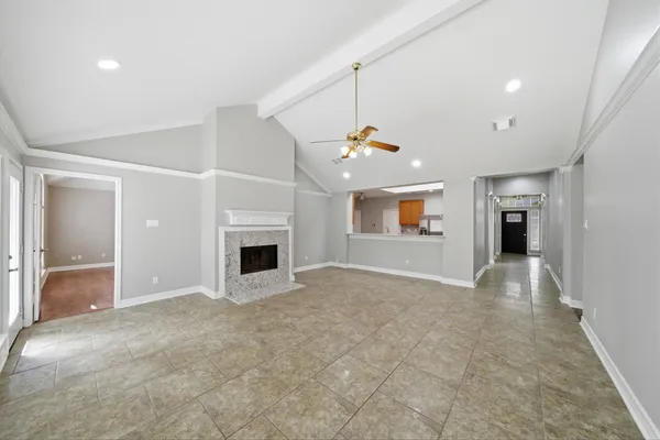 an empty room with a fireplace and entryway