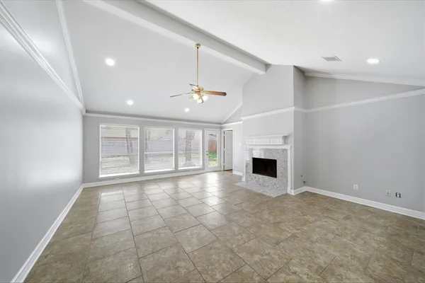 an empty room with windows and fireplace