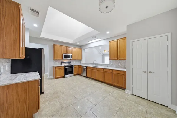 a large kitchen with a large counter top stainless steel appliances and cabinets