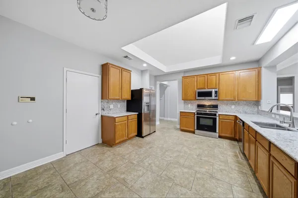 a large kitchen with a large window and stainless steel appliances