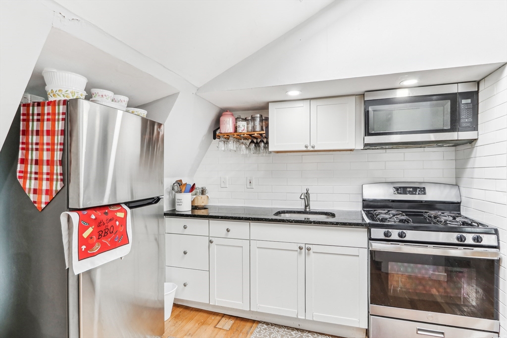 831 North Shore Road Revere, MA 02151 - Photo 15 of 24 a kitchen with stainless steel appliances a stove a microwave and cabinets