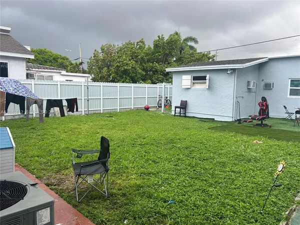 a view of a backyard with table and chairs and potted plants