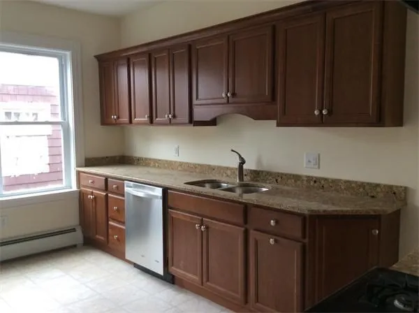 a kitchen with granite countertop stainless steel appliances a stove a sink and dishwasher next to a window