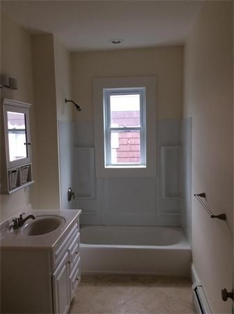 15 Romsey Street, Unit 3 Boston, MA 02125 - Photo 11 of 14 a bathroom with a tub sink toilet and a window