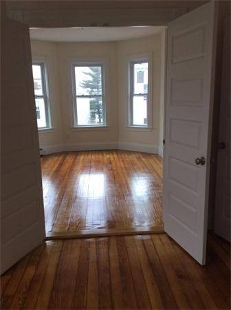 15 Romsey Street, Unit 3 Boston, MA 02125 - Photo 5 of 14 a view of an empty room with wooden floor and a window