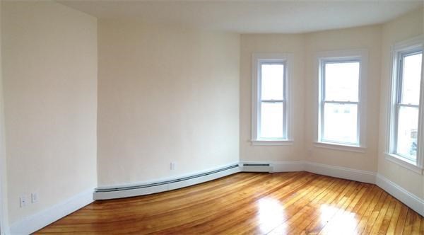 15 Romsey Street, Unit 3 Boston, MA 02125 - Photo 9 of 14 an empty room with wooden floor and windows