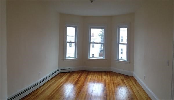 15 Romsey Street, Unit 3 Boston, MA 02125 - Photo 10 of 14 an empty room with wooden floor and windows