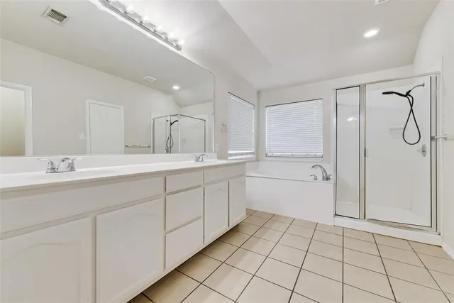 a spacious bathroom with a granite countertop sink a mirror and a bathtub