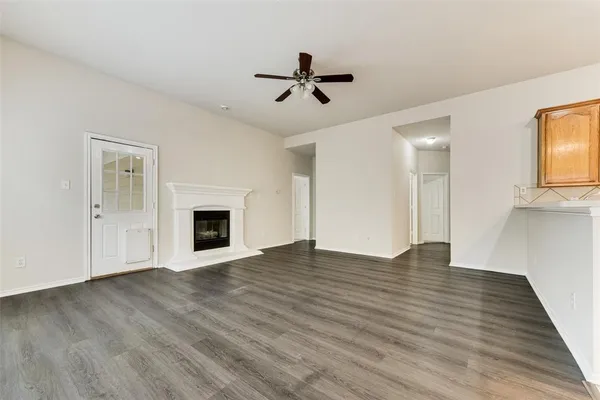 a view of empty room with wooden floor and fireplace