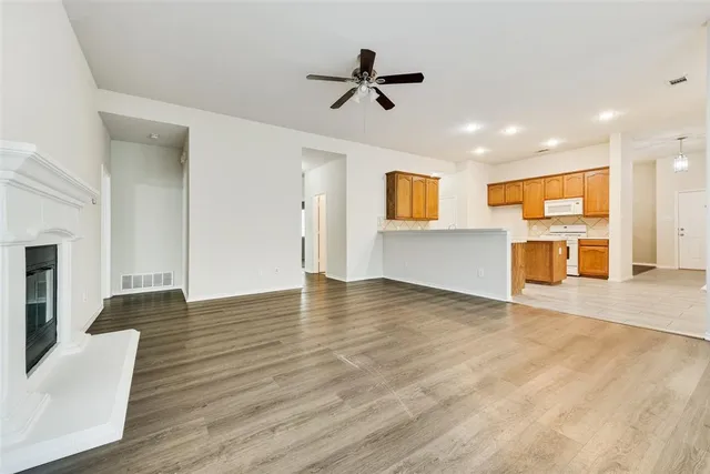 a view of empty room with wooden floor and a ceiling fan