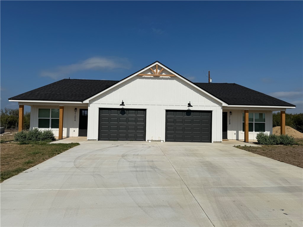 a front view of a house with yard and parking