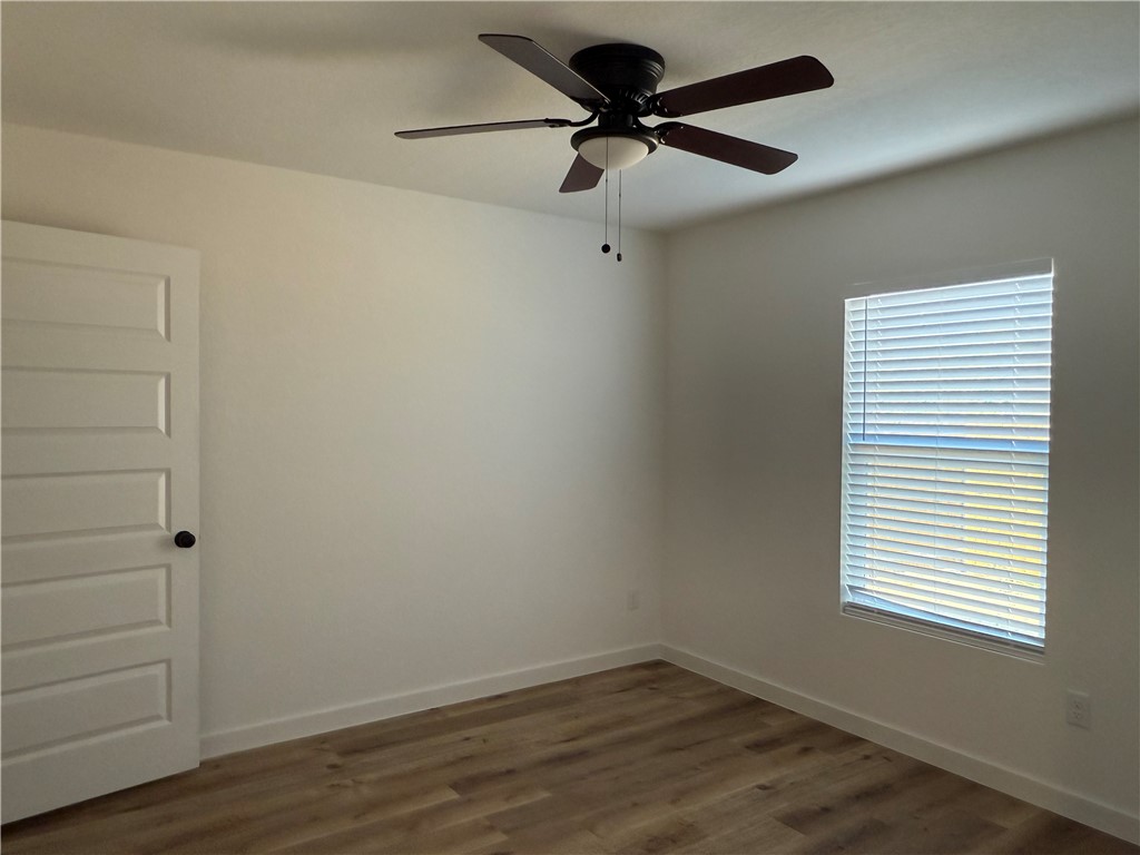 2105 Vista Rosa Three Rivers, TX 78071 - Photo 6 of 10 a view of a small space with wooden floor a ceiling fan and a window