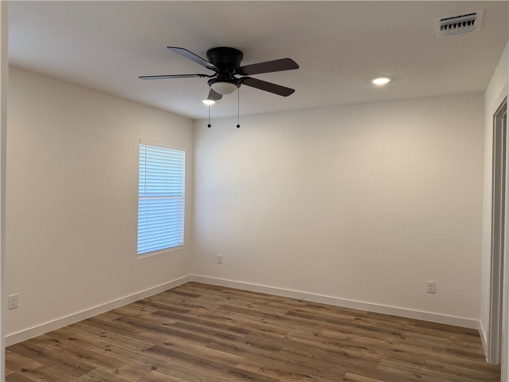 2105 Vista Rosa Three Rivers, TX 78071 - Photo 7 of 10 an empty room with wooden floor fan and windows